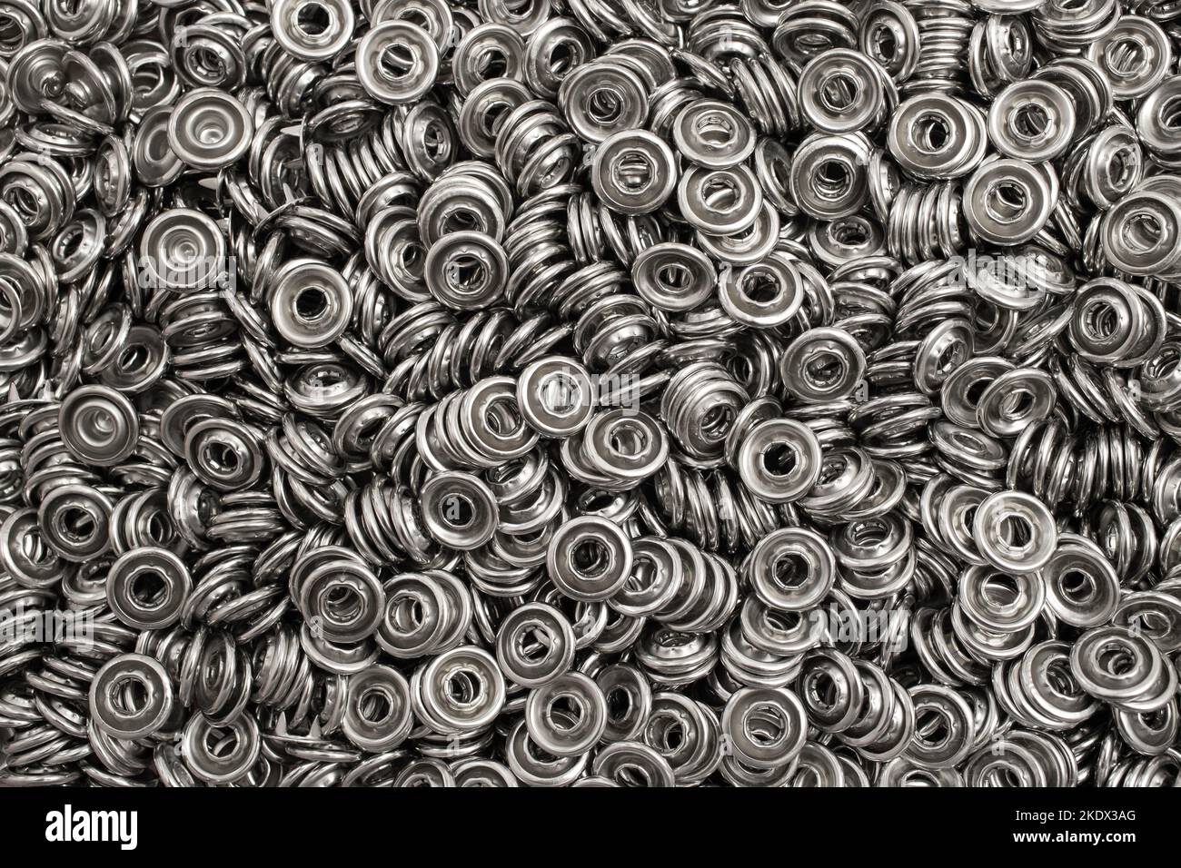 Metal eyelets for sewing. Grommets for clothes. Silver Metal background
