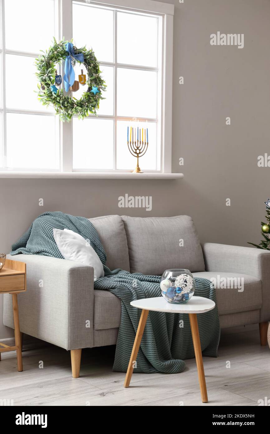 Interior of living room with sofa and window decorated for Hanukkah ...