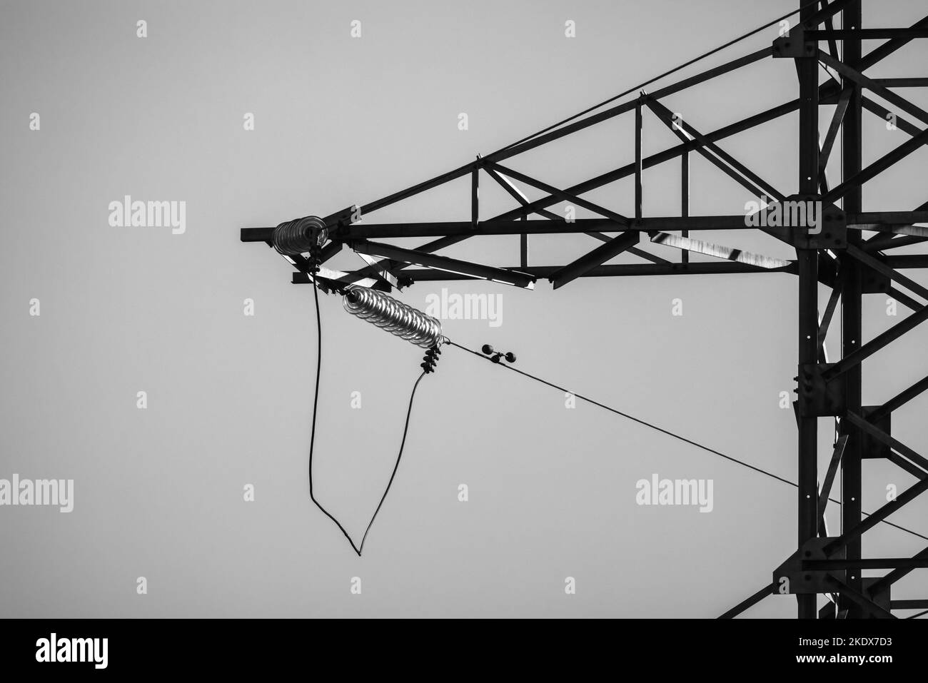Lattice-type steel tower as a part of high-voltage overhead power line. Black and white industrial photo Stock Photo