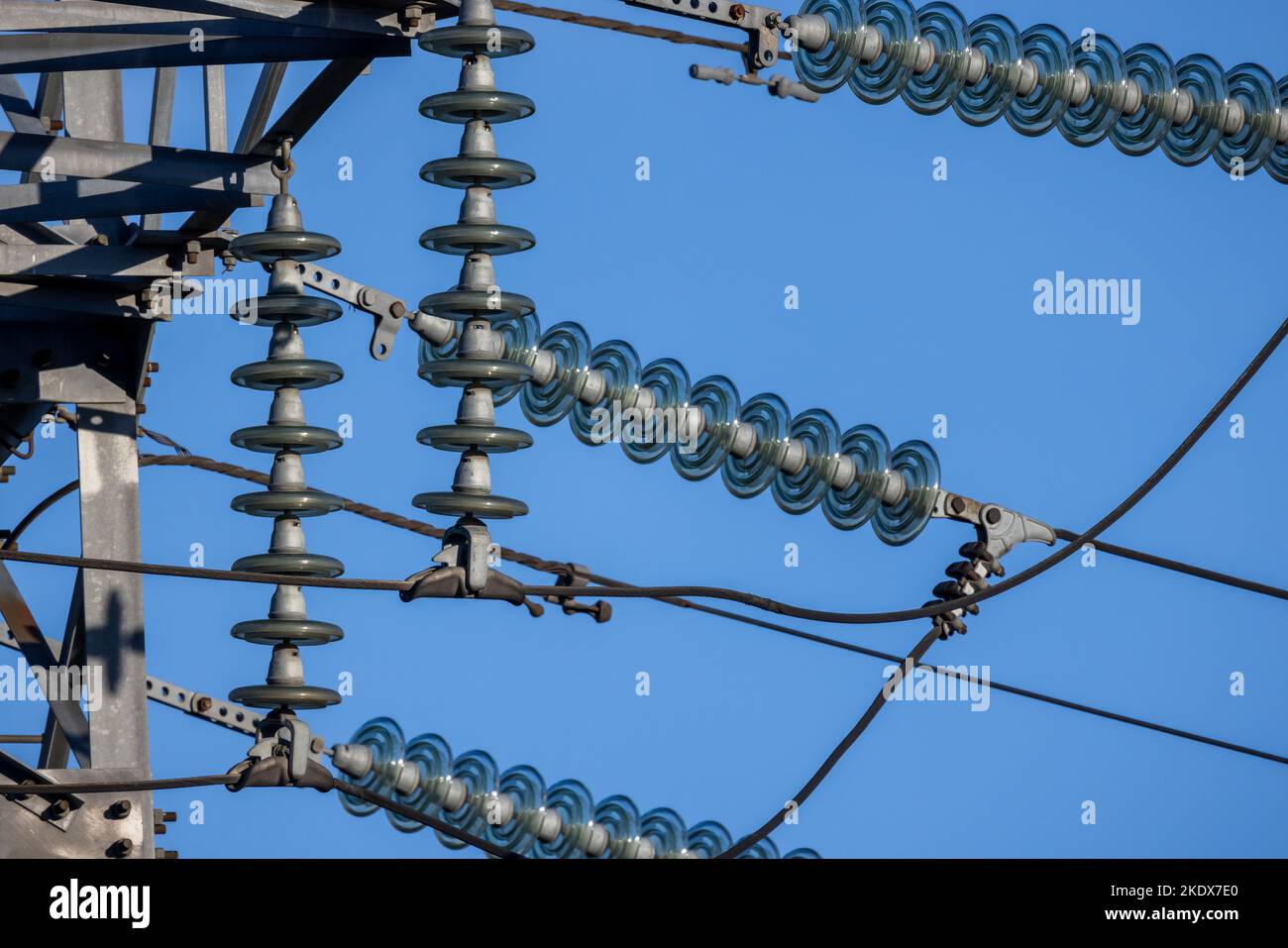 Insulators used in overhead power lines are under blue sky on a daytime Stock Photo