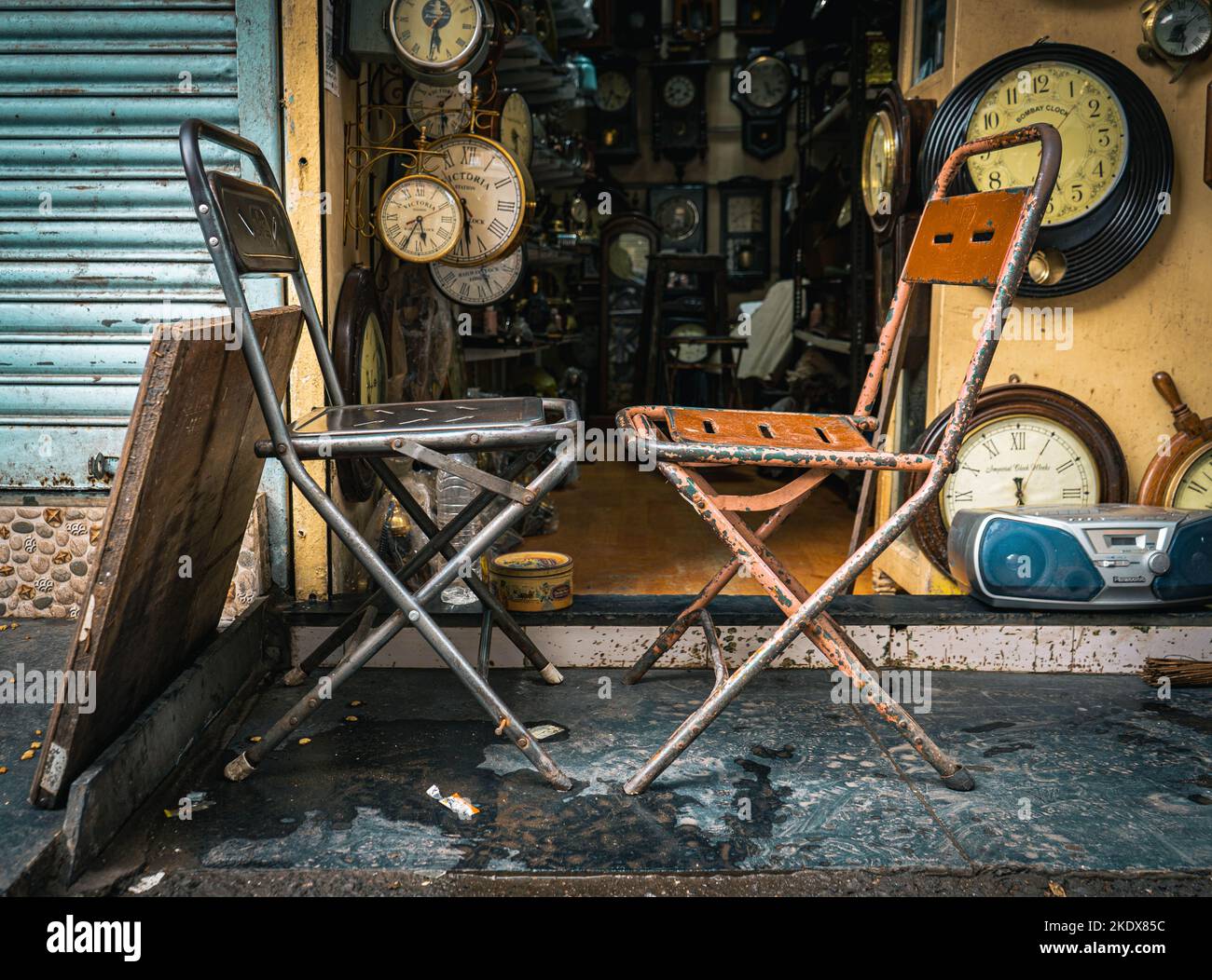 two empty chairs facing each other with clocks in the background Stock Photo