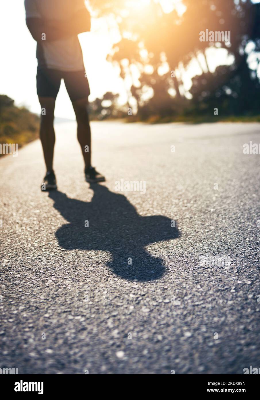 Be fierce and face your own shadow. a runner standing on the road Stock