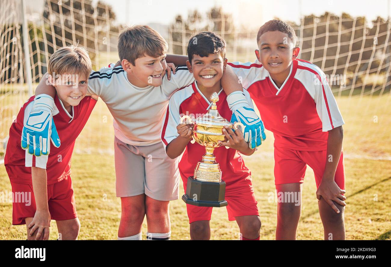 Football, teamwork and sports with trophy and children at goal post for winner, happy and fitness. Exercise, success and award with soccer player Stock Photo