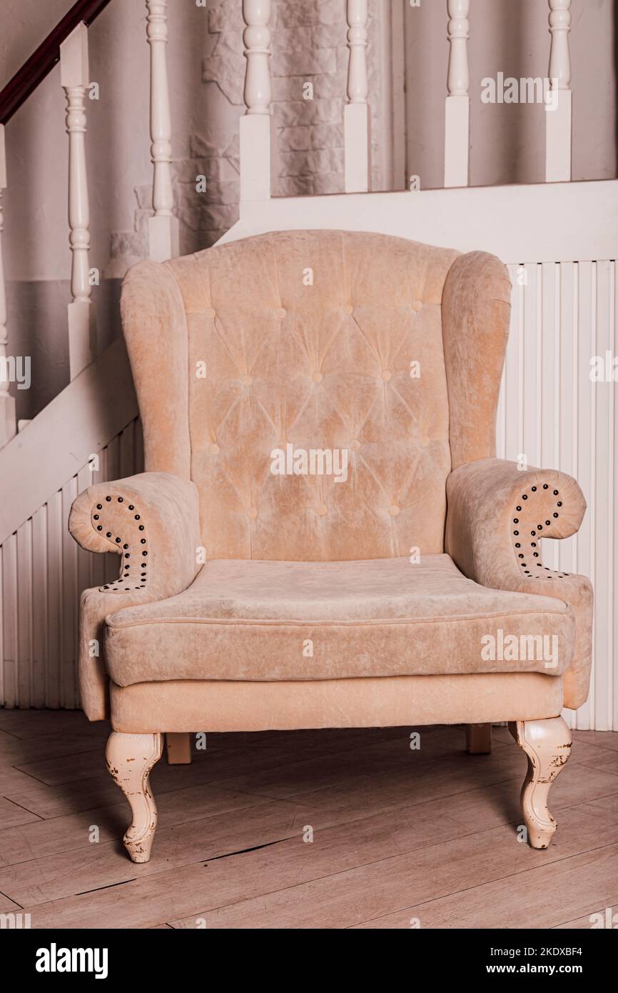 Beige soft chair in the home interior near the stairs Stock Photo