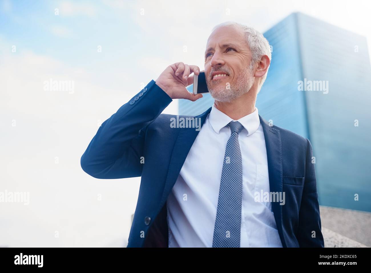 Connected to his business on the go. a businessman answering his phone while walking to his office in the city. Stock Photo