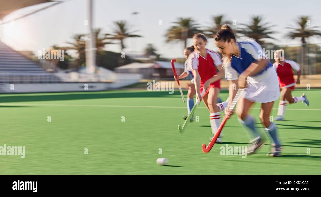 Sports, hockey and women in action on field playing game, match and training in outdoor stadium. Fitness, exercise and blur of female athletes running Stock Photo