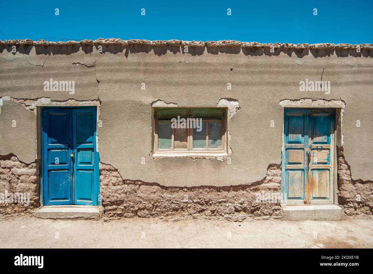 village building with two locked blue doors in Uyuni, Bolivia Stock Photo