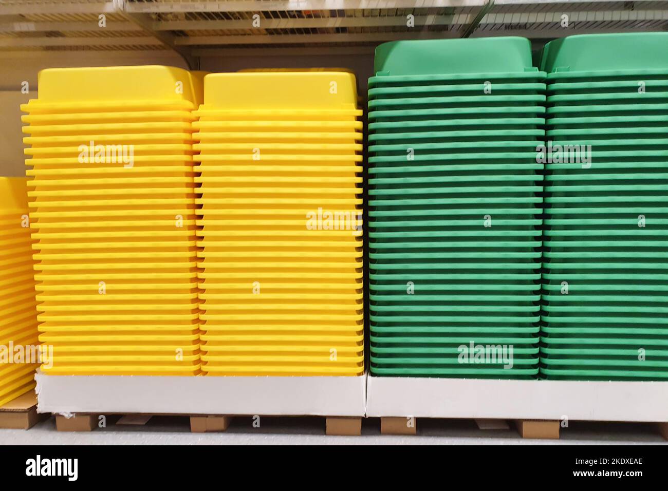 Yellow and green pile plastic containers without lids a lot in storage