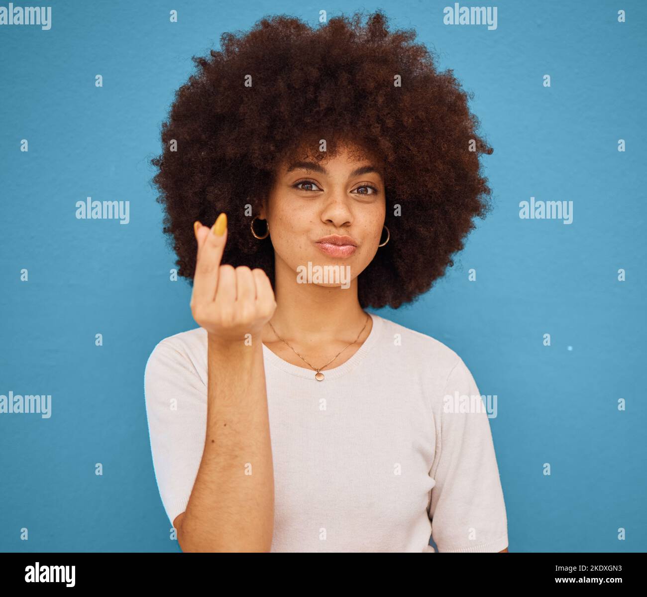 Hand, korean symbol and portrait of happy woman with an afro from Puerto Rico in the studio. Happiness, care and girl model doing kpop i love you Stock Photo