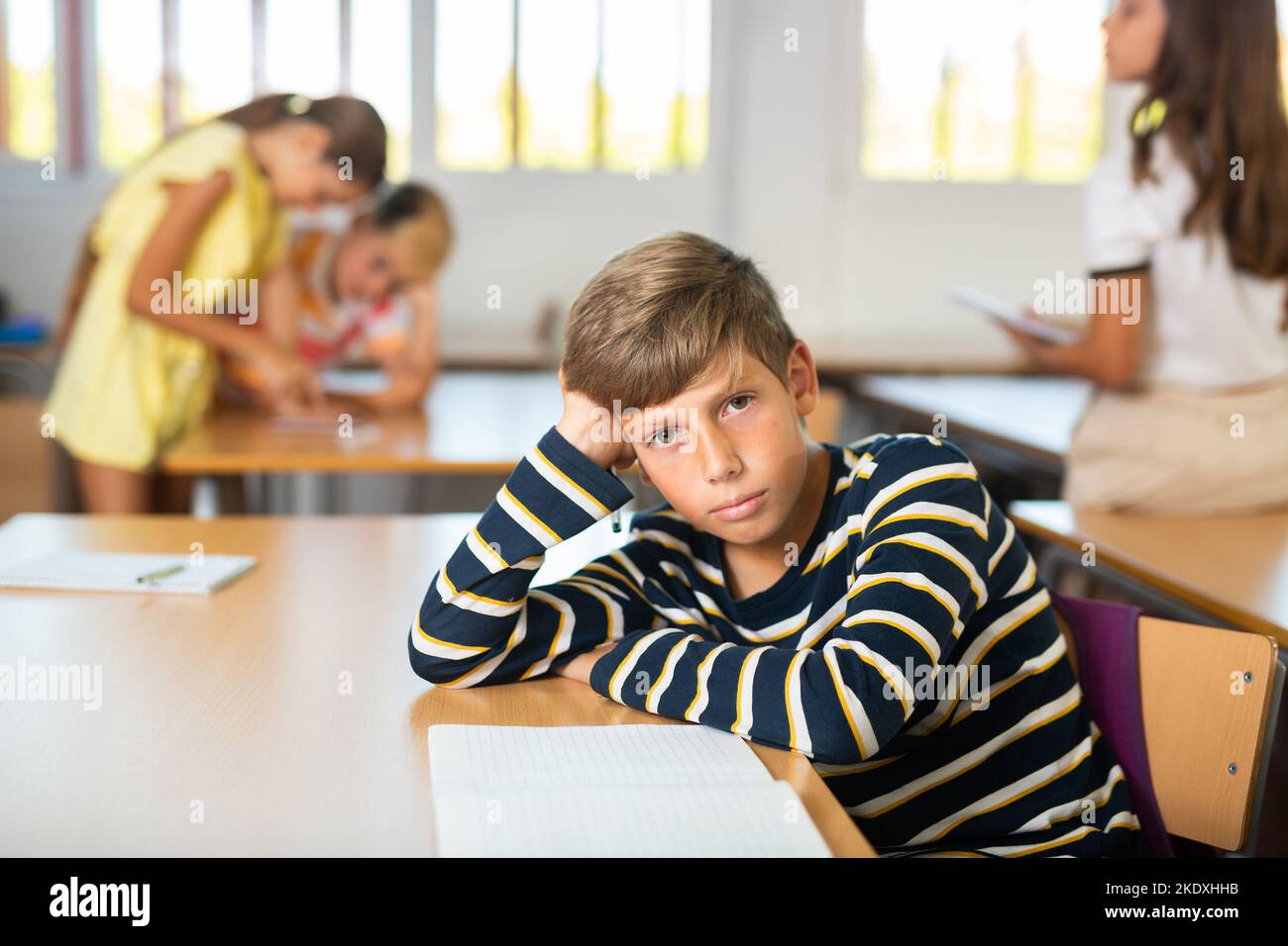 School boy sitting at the desk in classroom at lesson in primary school