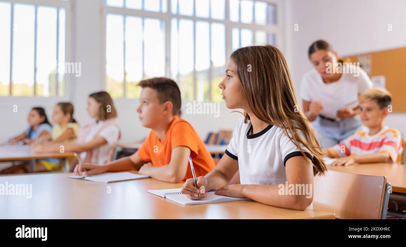 Portrait of school girl who writing exercises at lesson in school Stock ...