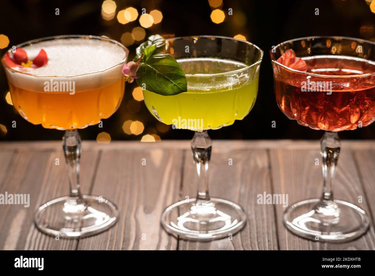 Three different cocktails in warm colors on a light background
