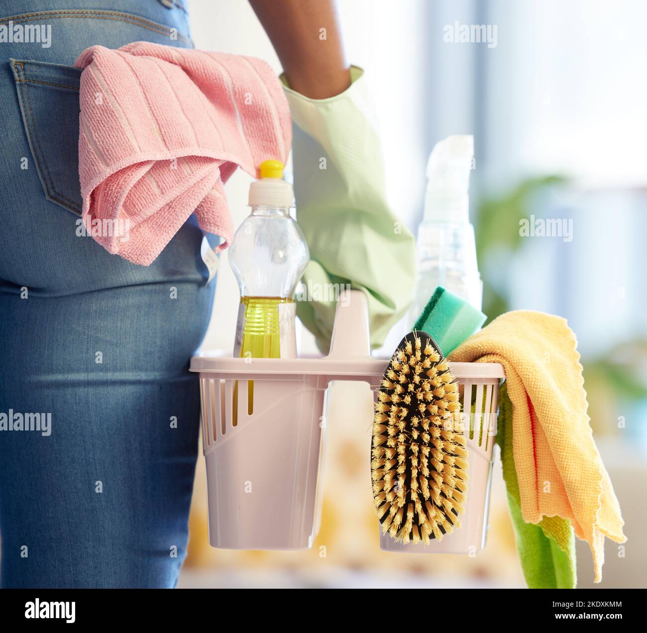 Hand, cleaning products and home supplies for house cleaning service. Cleaner, chemical basket and hygiene safety tools for spring clean worker in Stock Photo