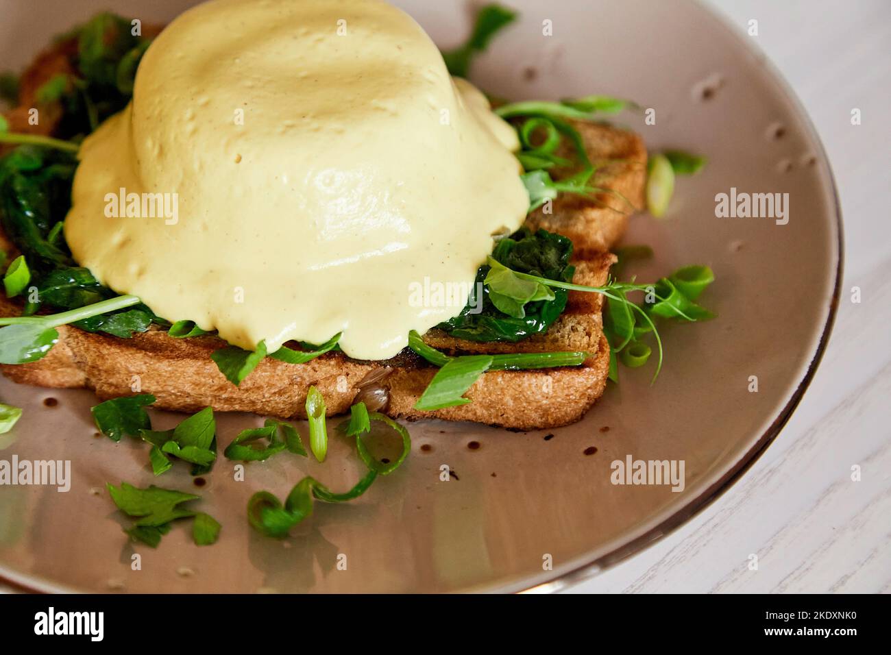 Close up of vegan alternative eggs benedict dish with wholegrain bread