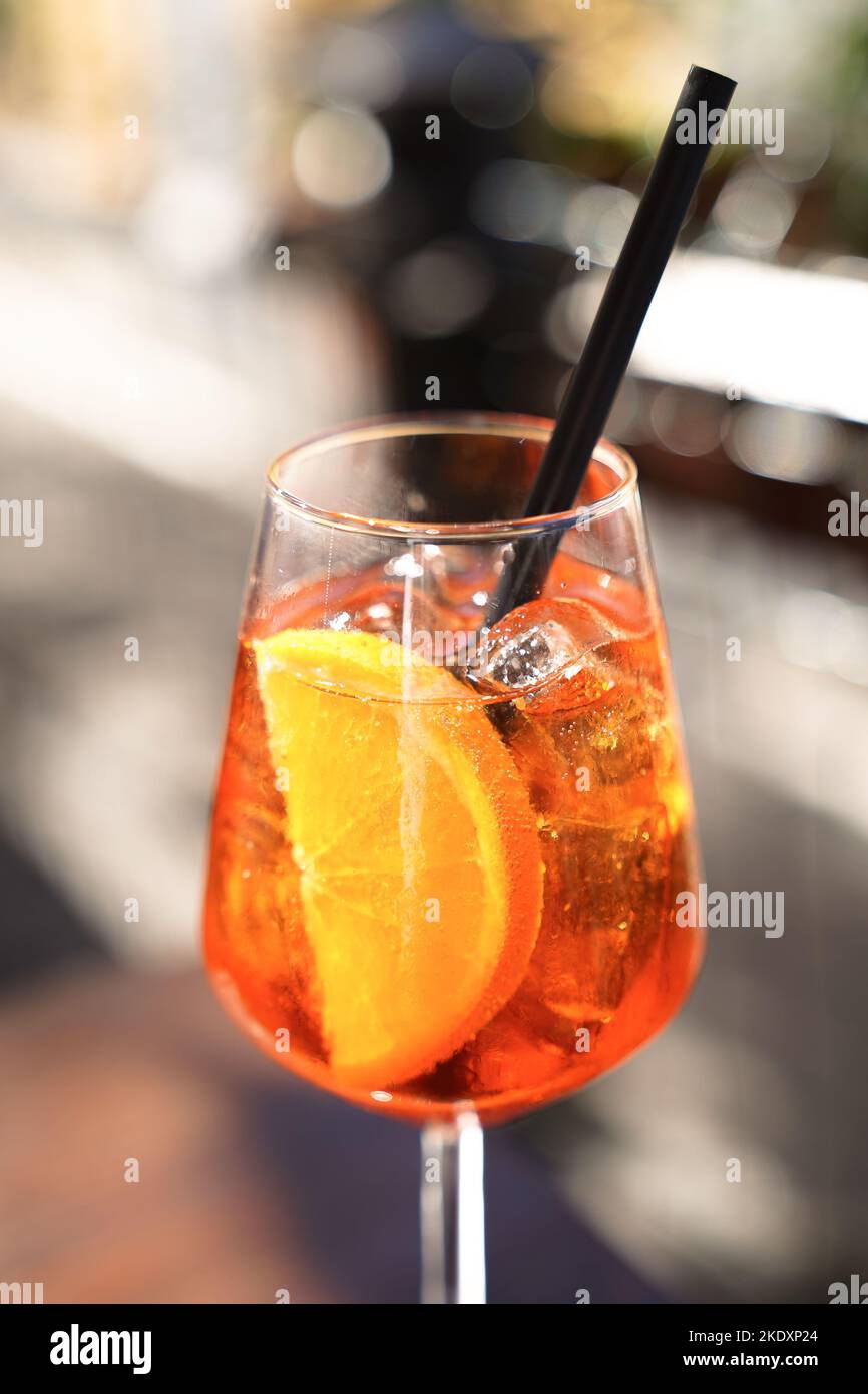 Served cocktail of Aperol spritz with orange slice and straw placed on ...