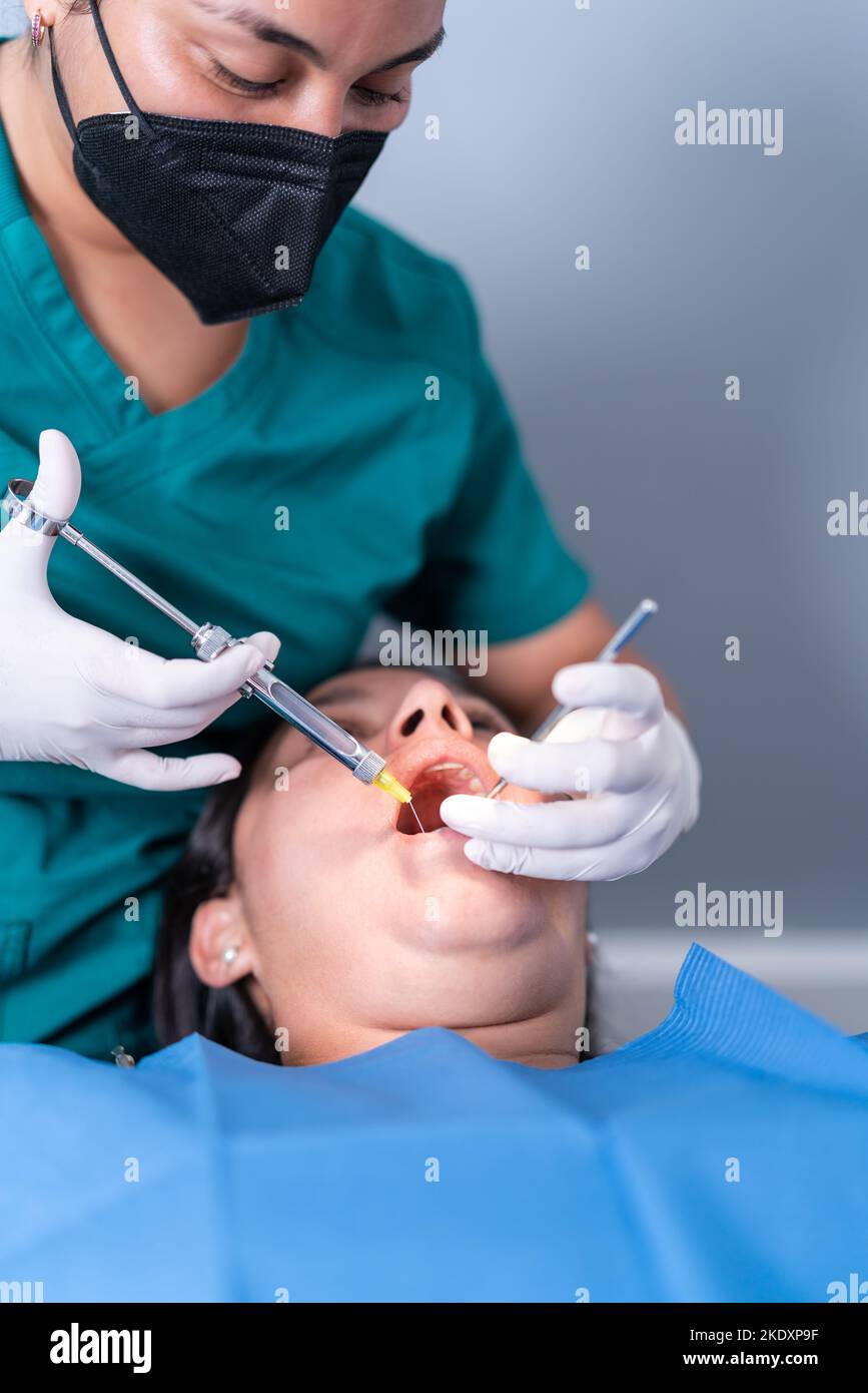 Crop unrecognizable dentist using syringe while making anesthetic