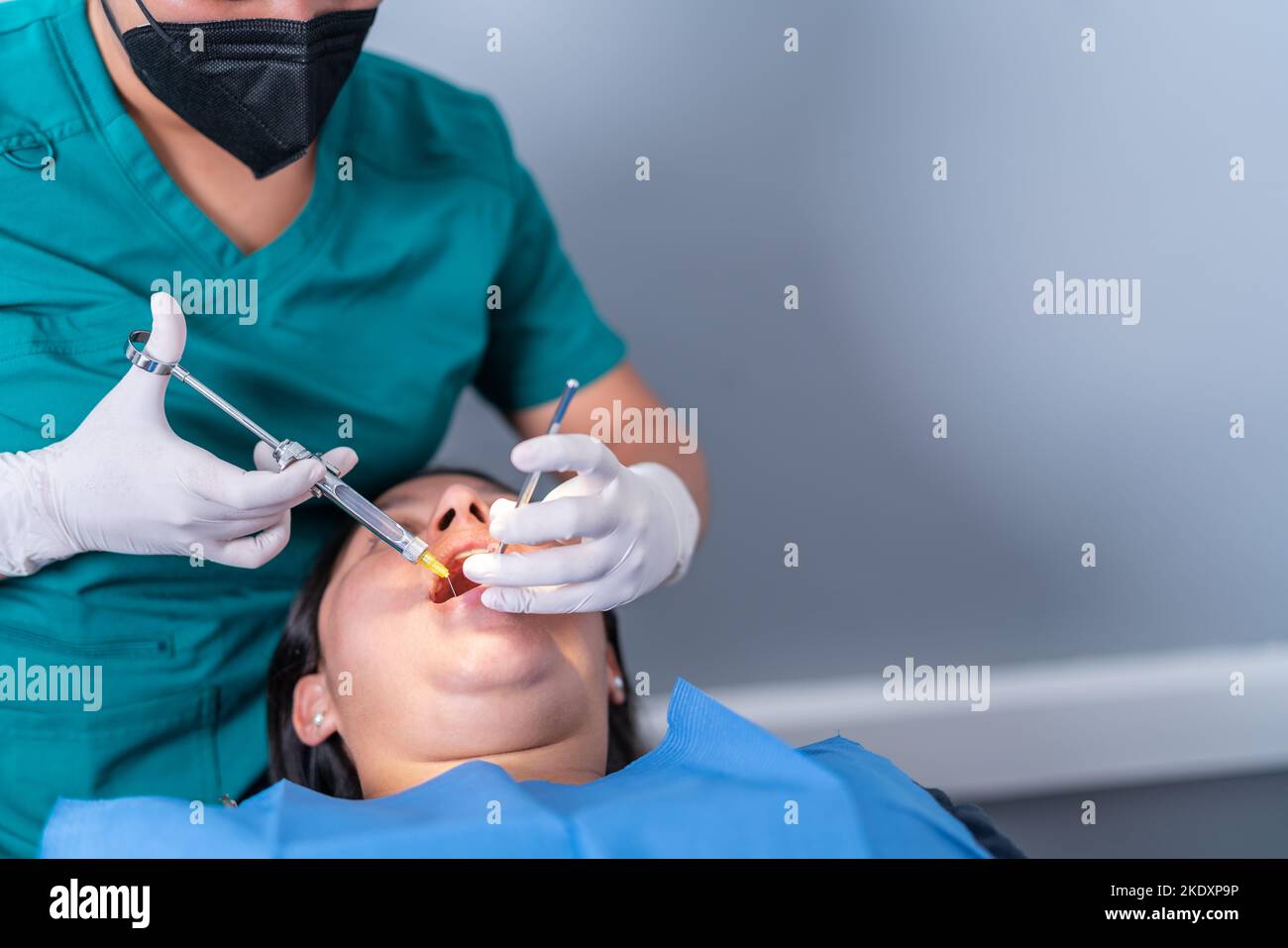 Crop unrecognizable dentist using syringe while making anesthetic