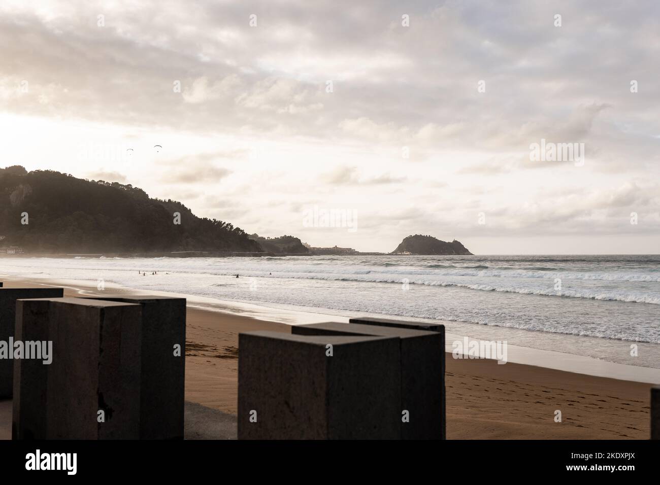 Sea waves rolling on sandy beach against cloudy sundown sky in evening on resort Stock Photo