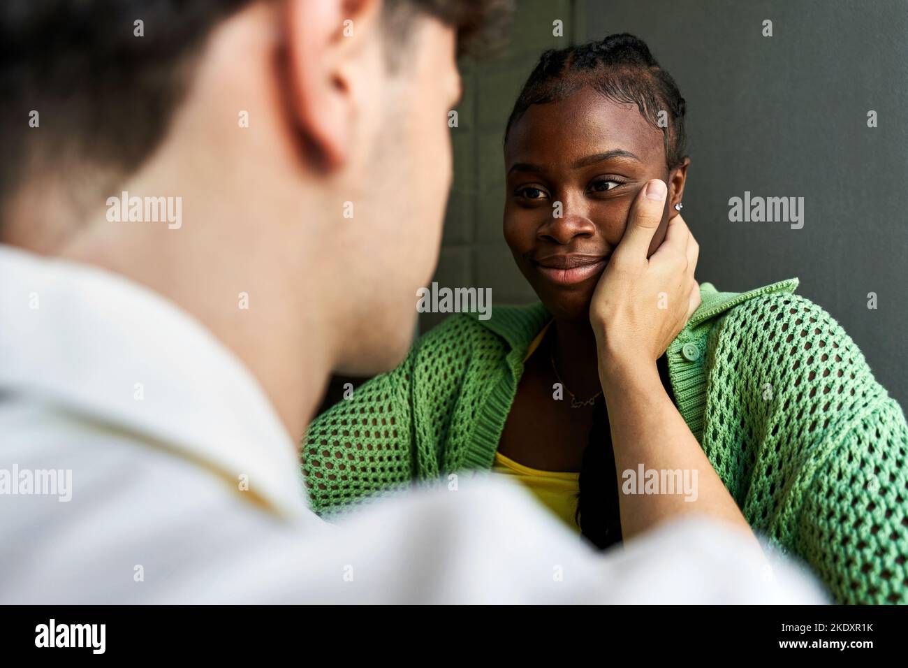 Crop Male Touching Cheek Of African American Girlfriend Gently During Romantic Date Against Gray