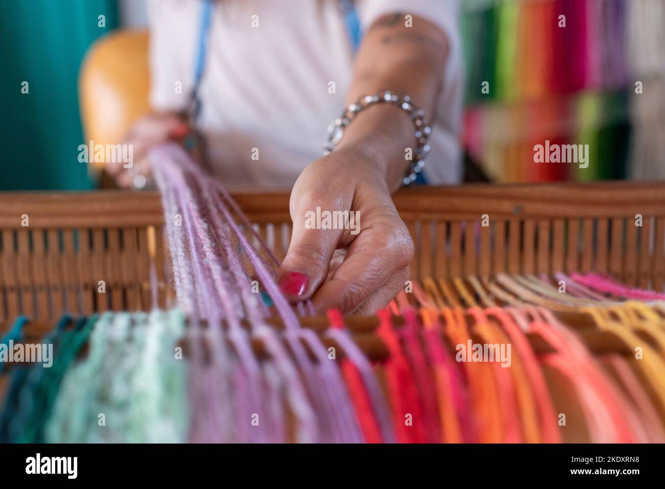 Threading Reeds Faceless skillful craftswoman threading slits of wooden reed while ...
