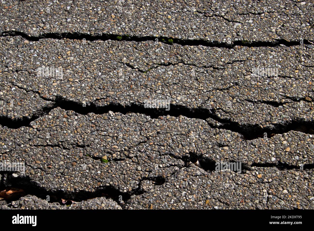 Crack in old worn asphalt road for background Stock Photo