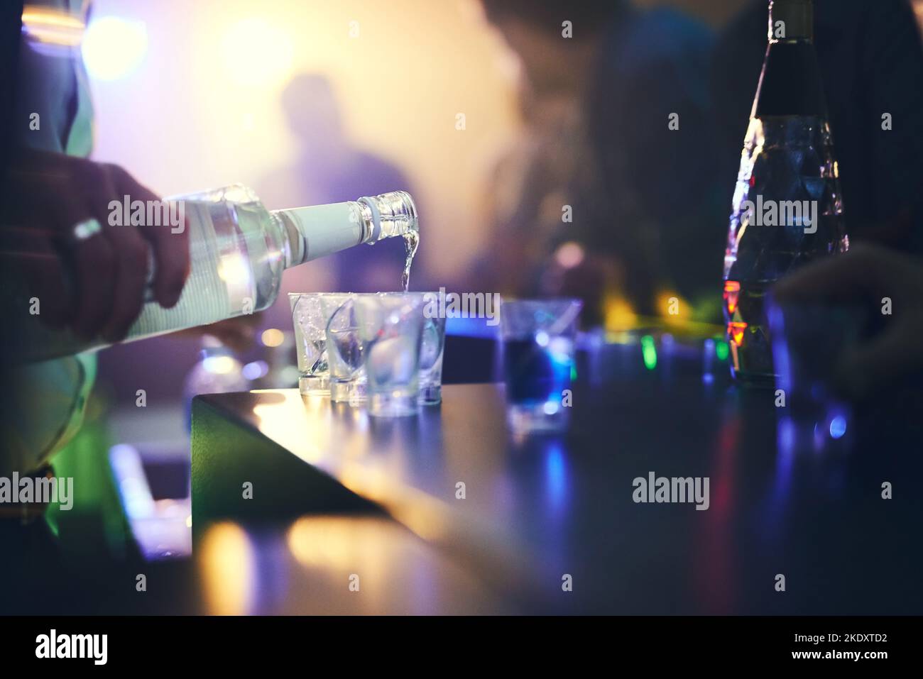 Liquid luck. an unidentifiable barman pouring shots in a nightclub. Stock Photo