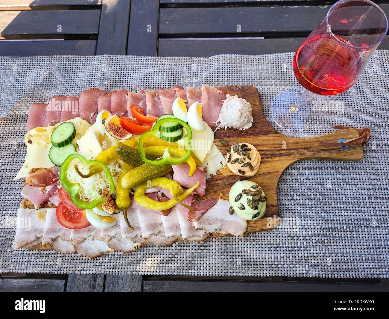 Austria, traditional cold plate with sausage, cheese, bacon and spreads called Brettljause with a glass of Schilcher wine Stock Photo