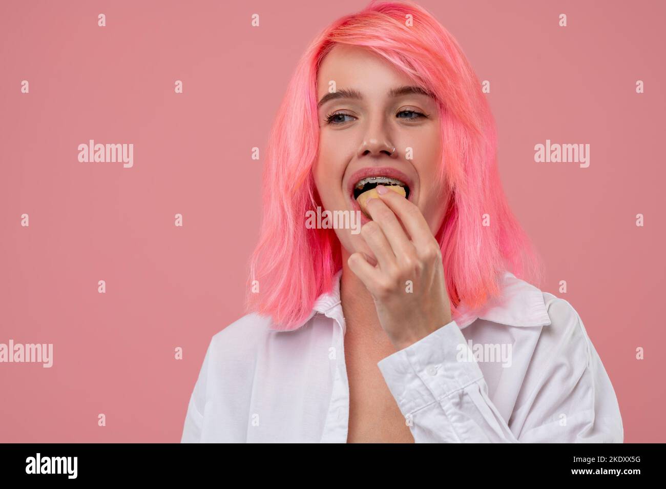 Girl with braces eating a fresh fruit Stock Photo Alamy