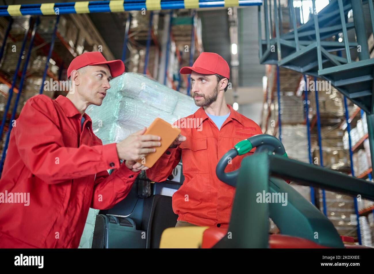 Warehouse manager communicating with a forklift driver Stock Photo Alamy