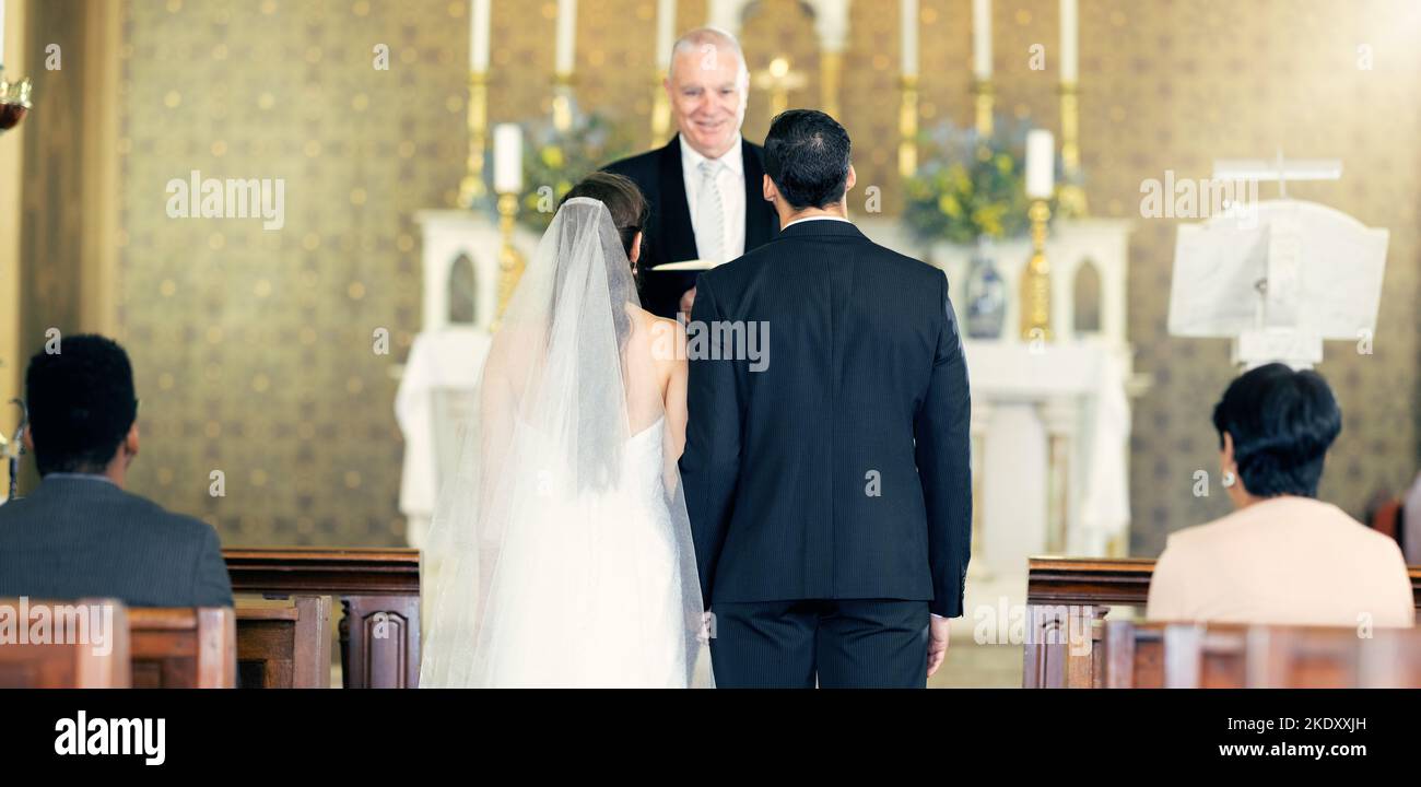 Couple, wedding and priest with commitment, love and marriage ceremony in church service together. Man, woman and pastor with trust, celebration and Stock Photo