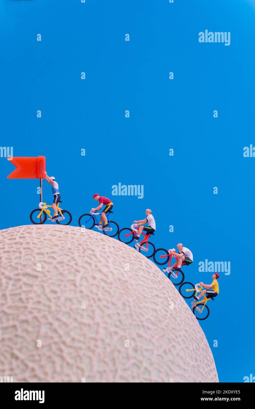 Miniature toys - road cyclist approaching finish line, celebration concept. Stock Photo