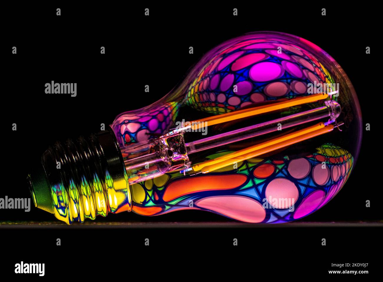 A Light Bulb on a black background with a bright pattern reflection