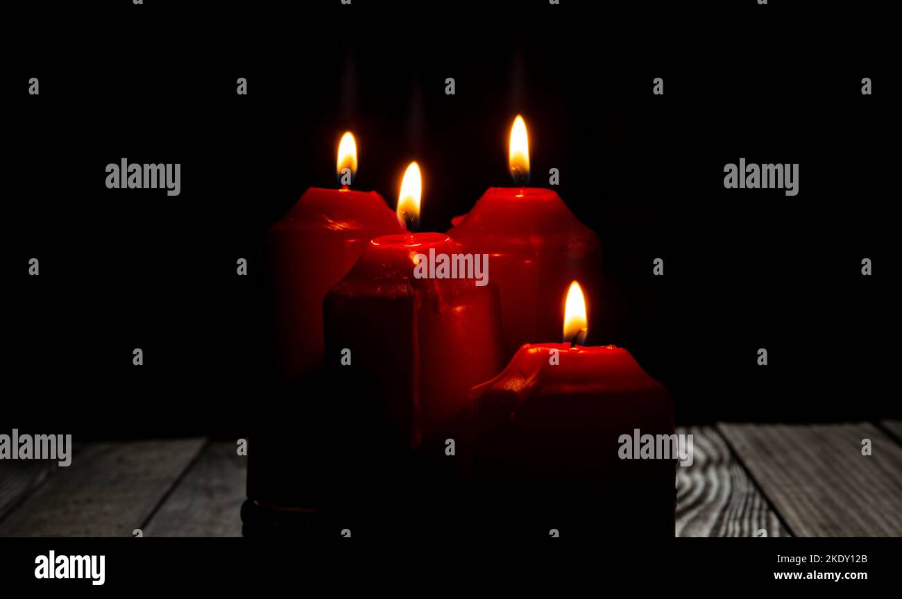 Four red candles light on dark room with dark background Stock Photo ...