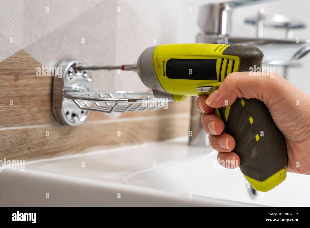 cordless screwdriver that wraps a screw into a hole in a ceramic tile