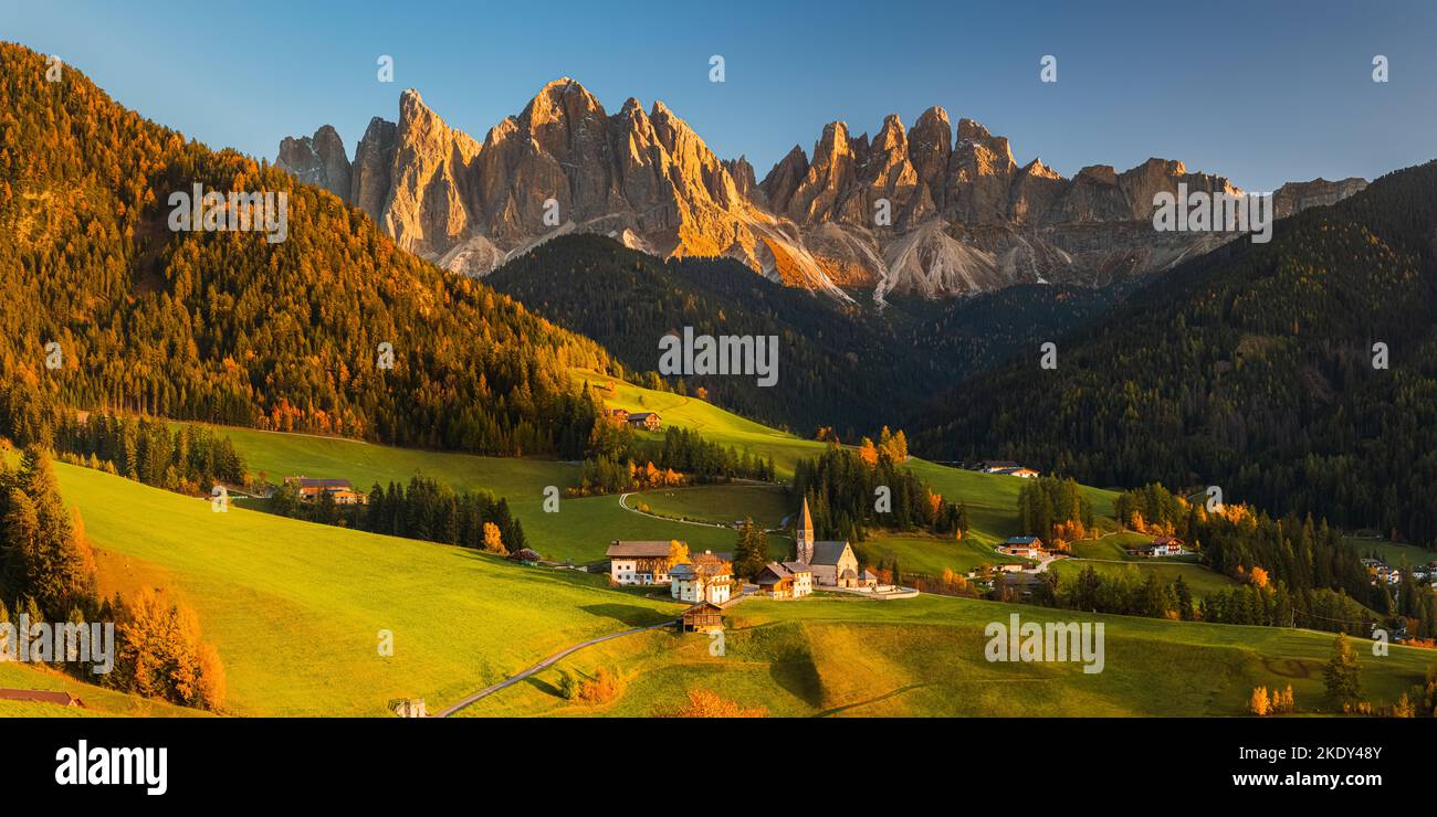 A 2:1 panorama image from an autumn sunset at the famous church and village of Santa Maddalena in front of the Geisler or Odle Dolomites mountain peak Stock Photo