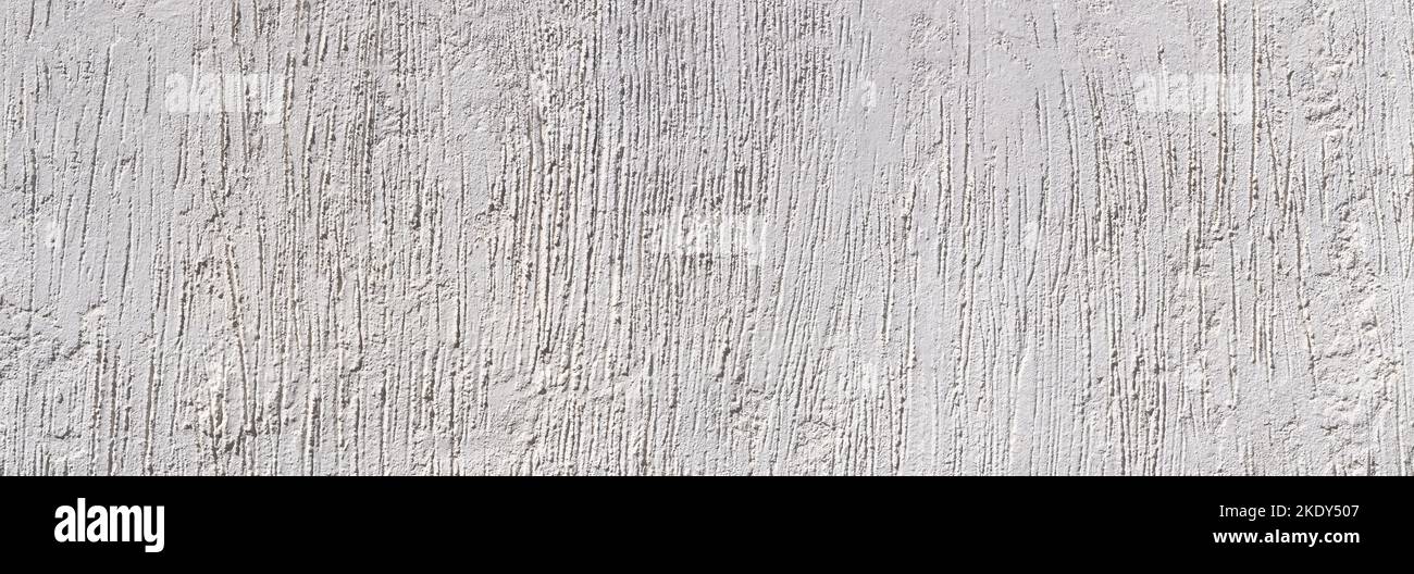 Light gray plaster with abstract pattern of rough vertical grooves