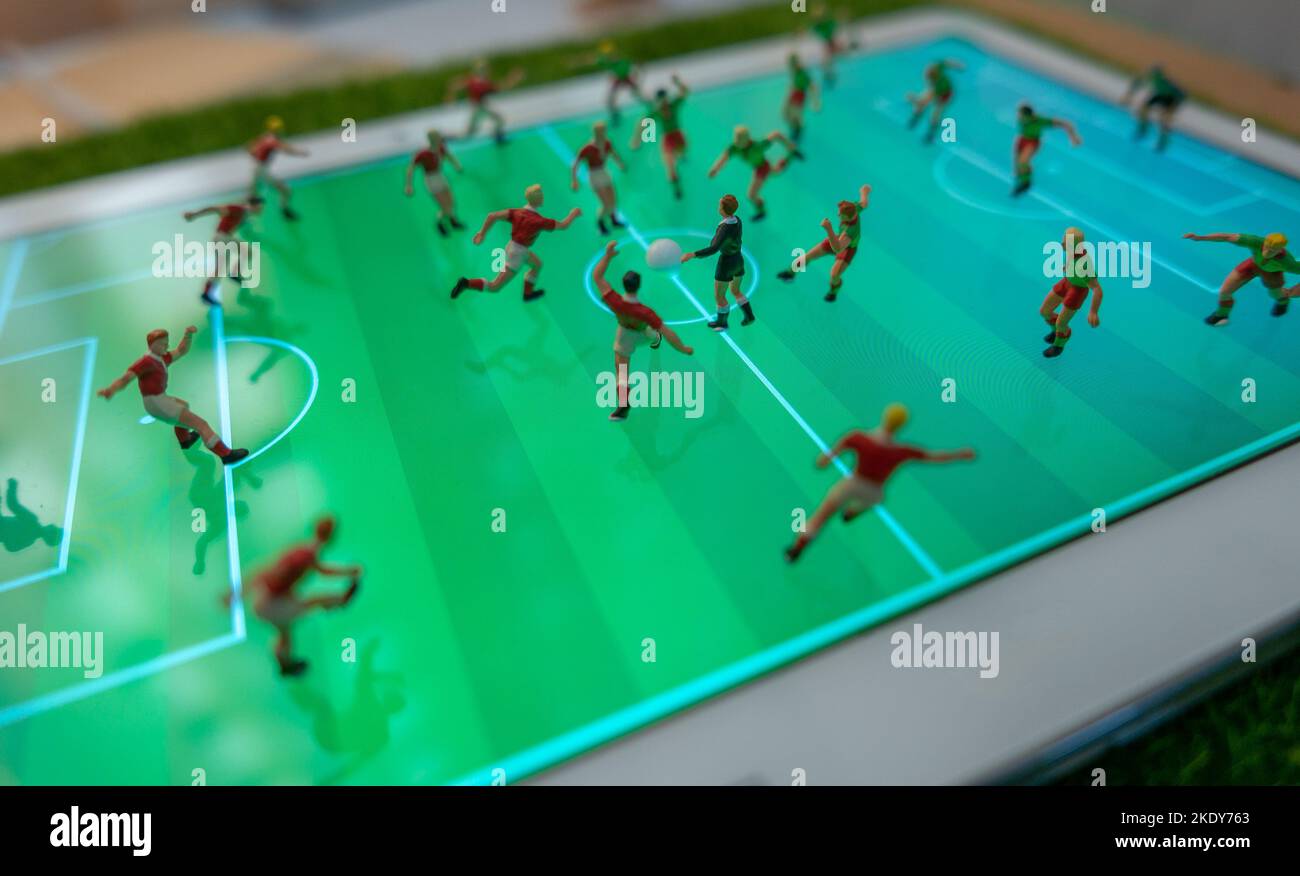 Side view of miniature toys figurines football (soccer) players on a computer pad (focus on the referee). Stock Photo