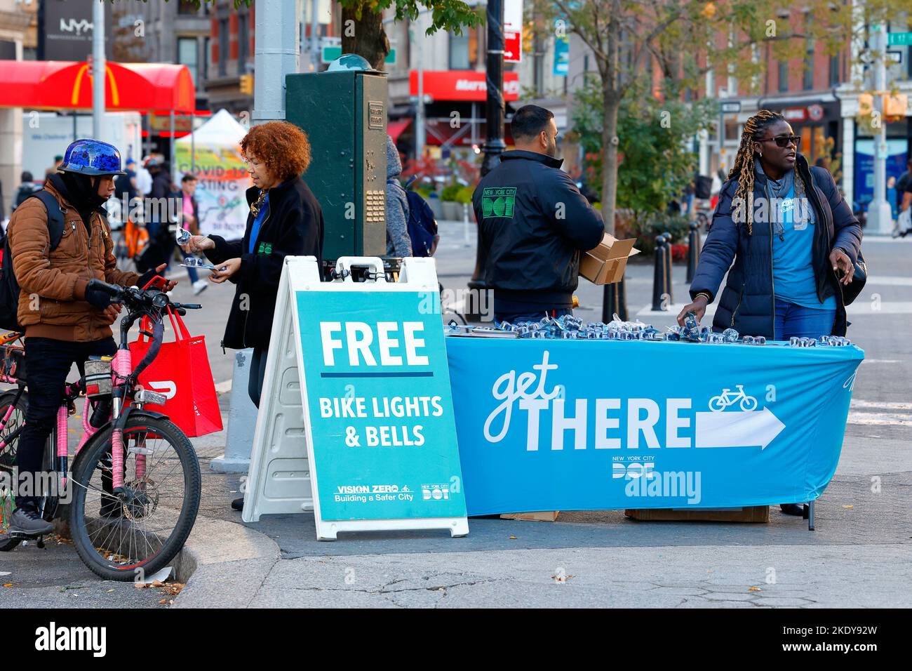 Workers from the NYC DOT distribute free bike lights and bells at a public outreach event as part of their 'Get There' and Vision Zero campaigns. Stock Photo