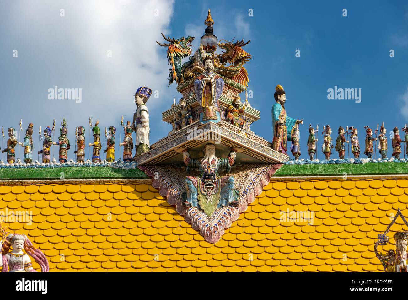 Figurative decoration on top of roof of Buddhist temple with blue sky, Wat Pariwat Bangkok, Thailand Stock Photo