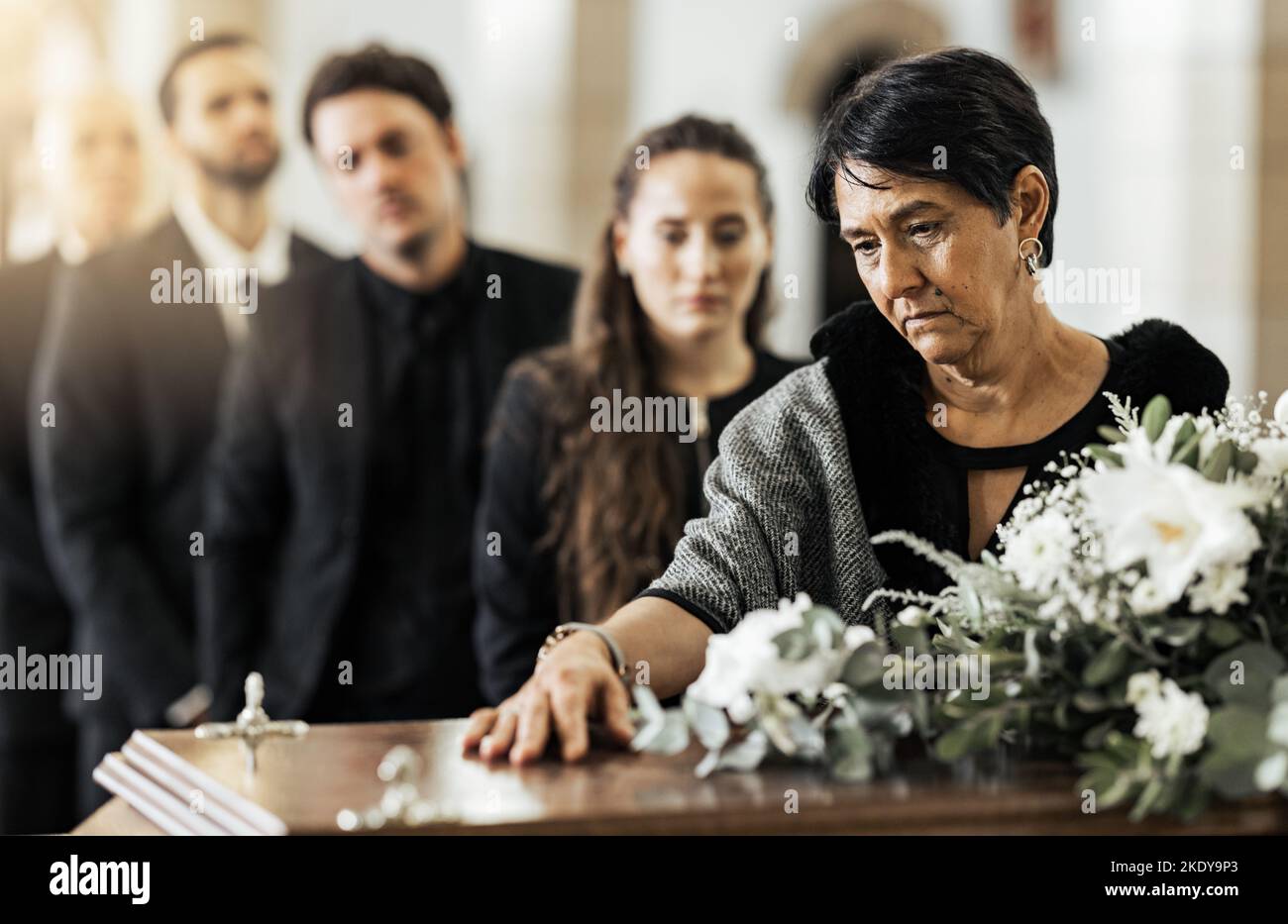 Funeral, death and coffin in church or Christian family gathering together for support. Religion, sad people and mourning loss or religious catholic Stock Photo