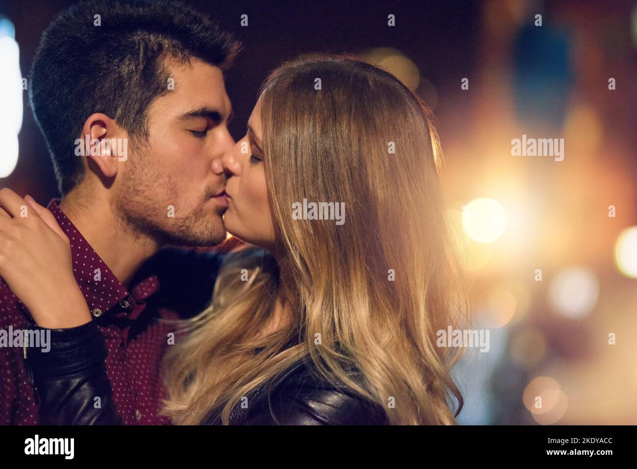 That kiss you hope never ends. a young couple sharing a romantic kiss together outside at night. Stock Photo