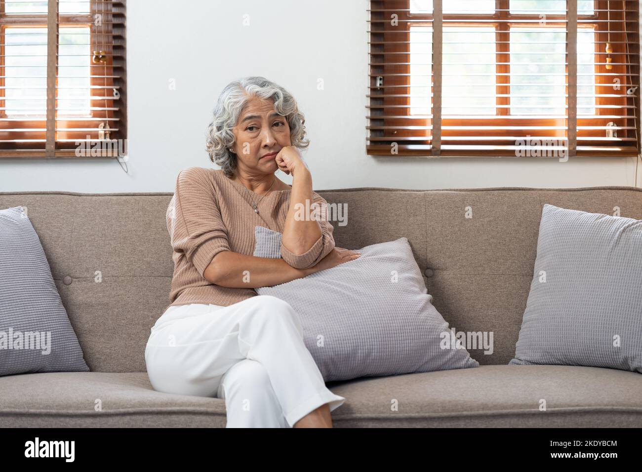 Asian elderly senior female at nursing home living room feeling sad missing unhappy thoughtful in mental health care in older people. Stock Photo