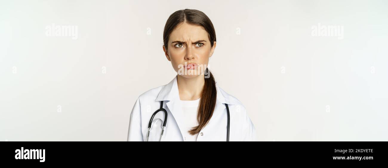 Angry and upset young woman doctor, female healthcare worker sulking ...