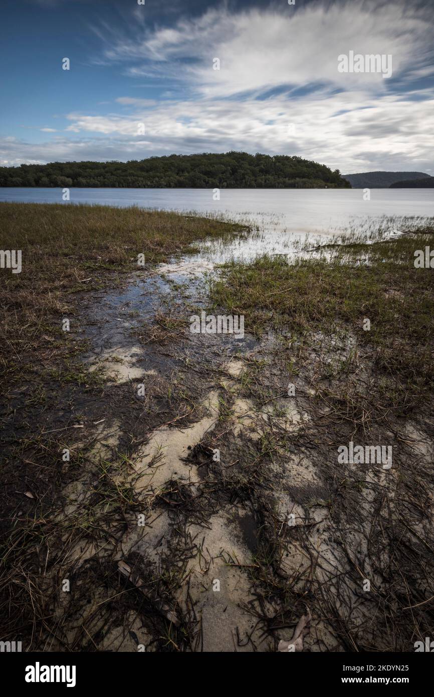 A vertical shot of the lake against the green valleys background Stock ...