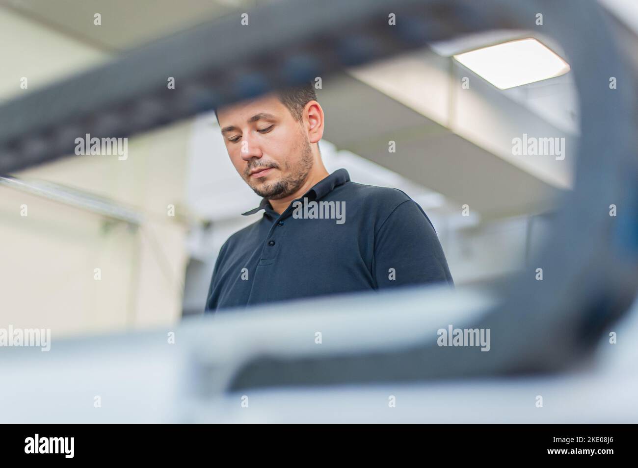 In the printing house, an experienced technician works on a UV printer. Production work. Check