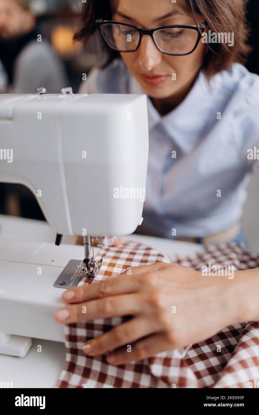 Dressmaker sewing on machine Stock Photo