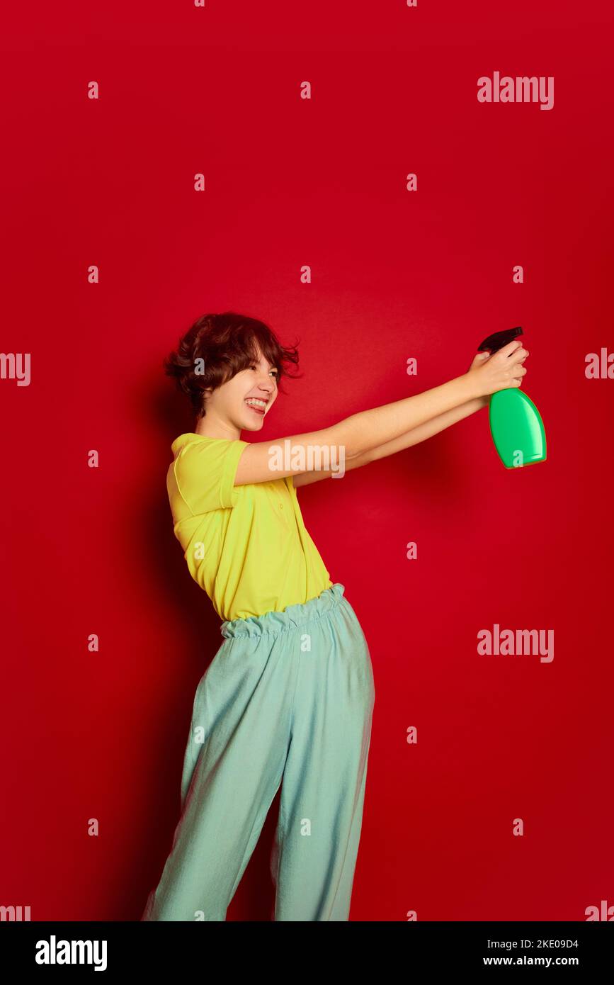 Portrait of cheerful teen girl with curly brown short hair posing with