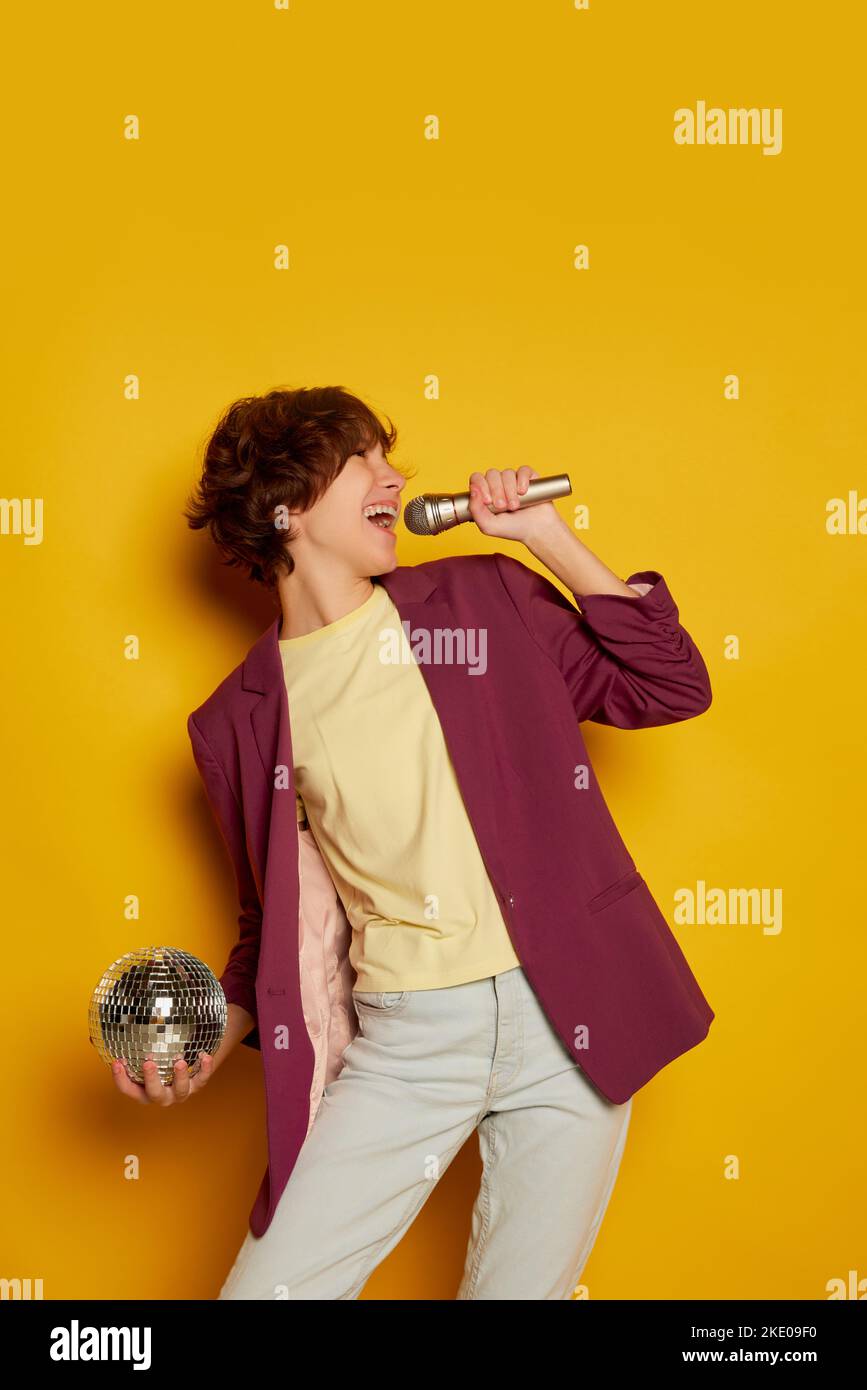 Portrait of teen girl with curly brown short hair posing in purple