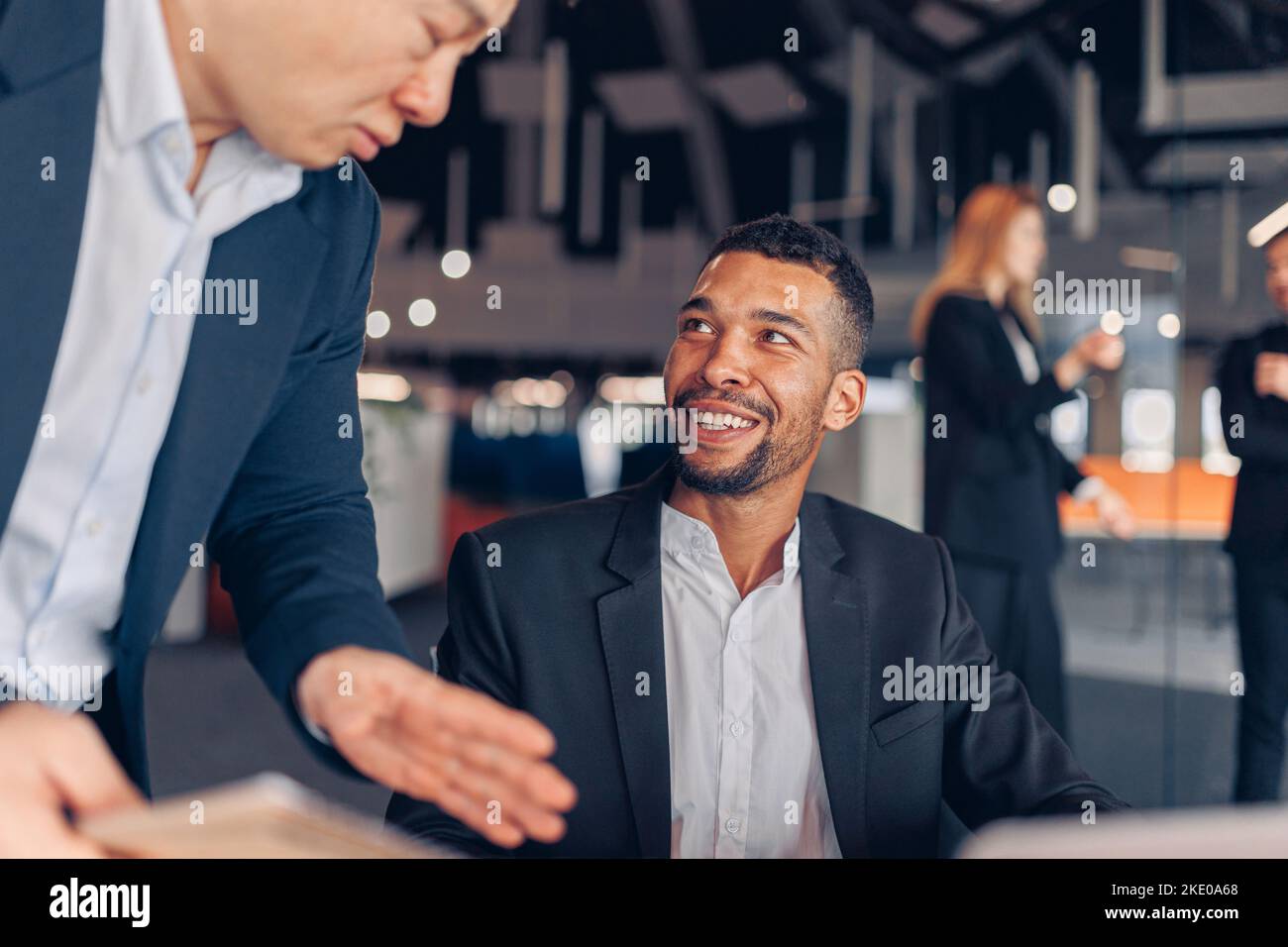 Two multiethnic colleagues working together on project in modern office Stock Photo