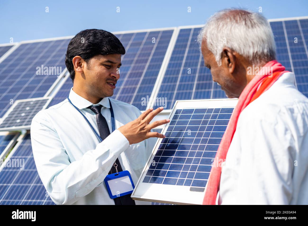 Banker or engineer explaining about solar panel or power usage to farmer for using in agriculture field - concept of sustainable lifestyle, support Stock Photo